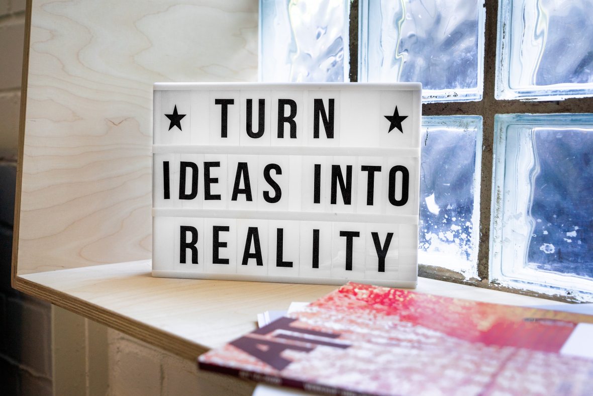 Photo of a sign sitting in a window nook. The sign says, "Turn ideas into reality."